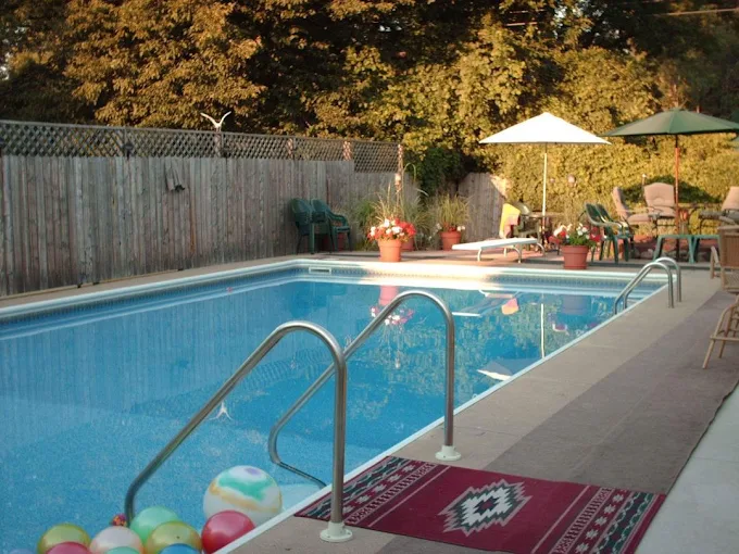Backyard swimming pool with patio furniture